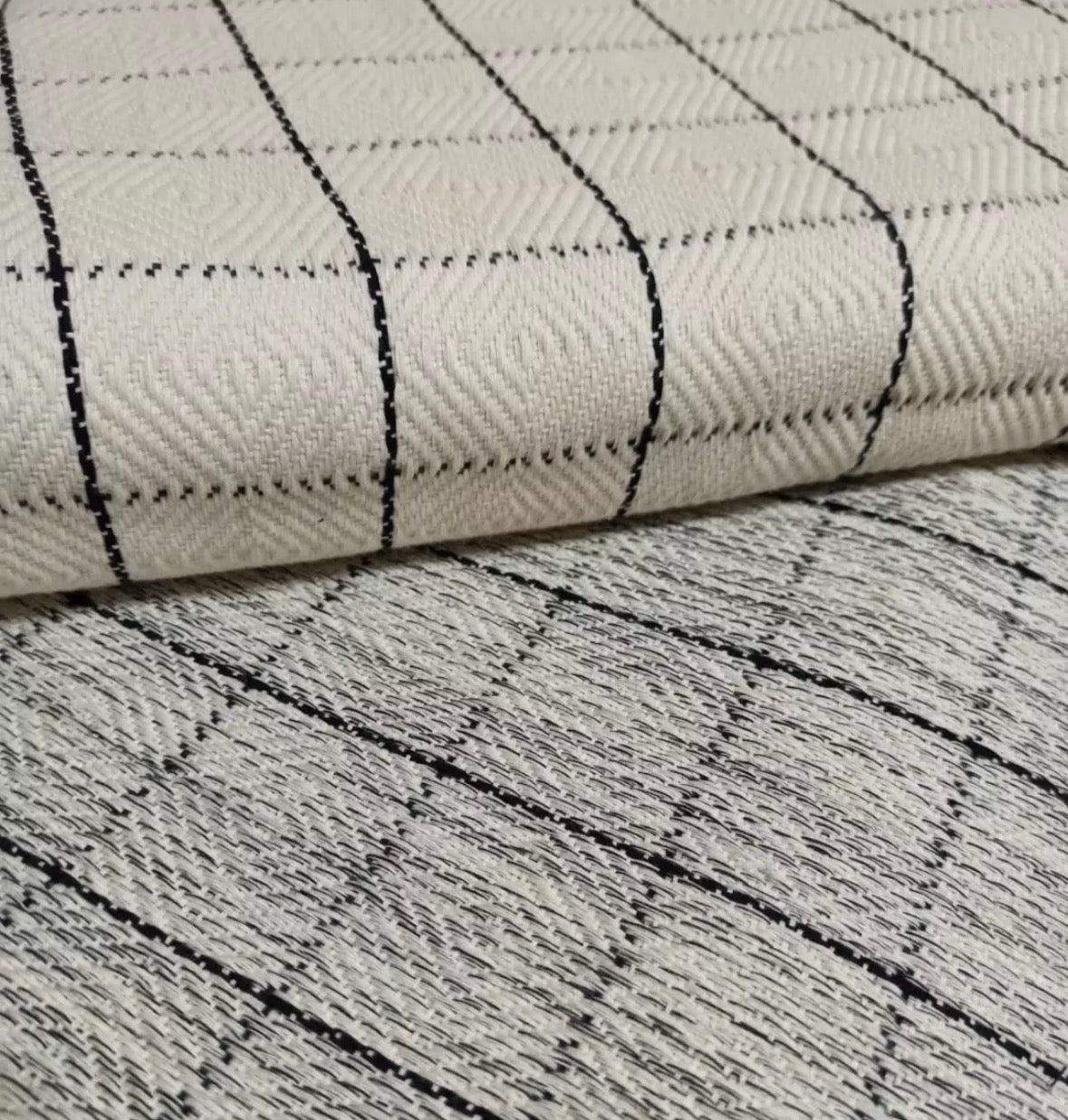 Close-up of textured fabric with black line patterns on a white background
