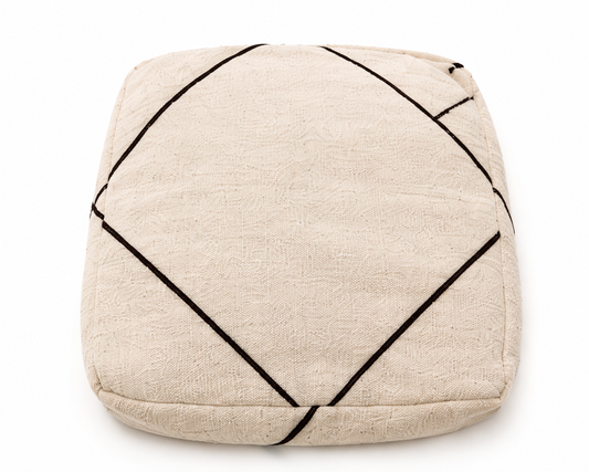 Beige pouf with black geometric lines on a white background