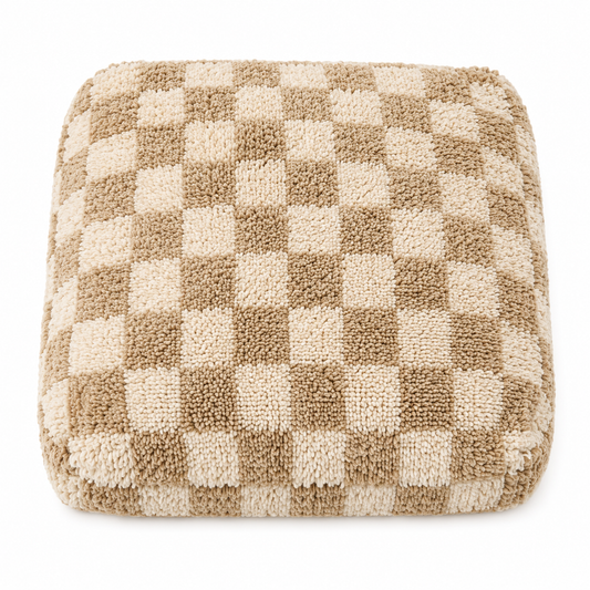 Checkered cushion with brown and beige squares on a white background