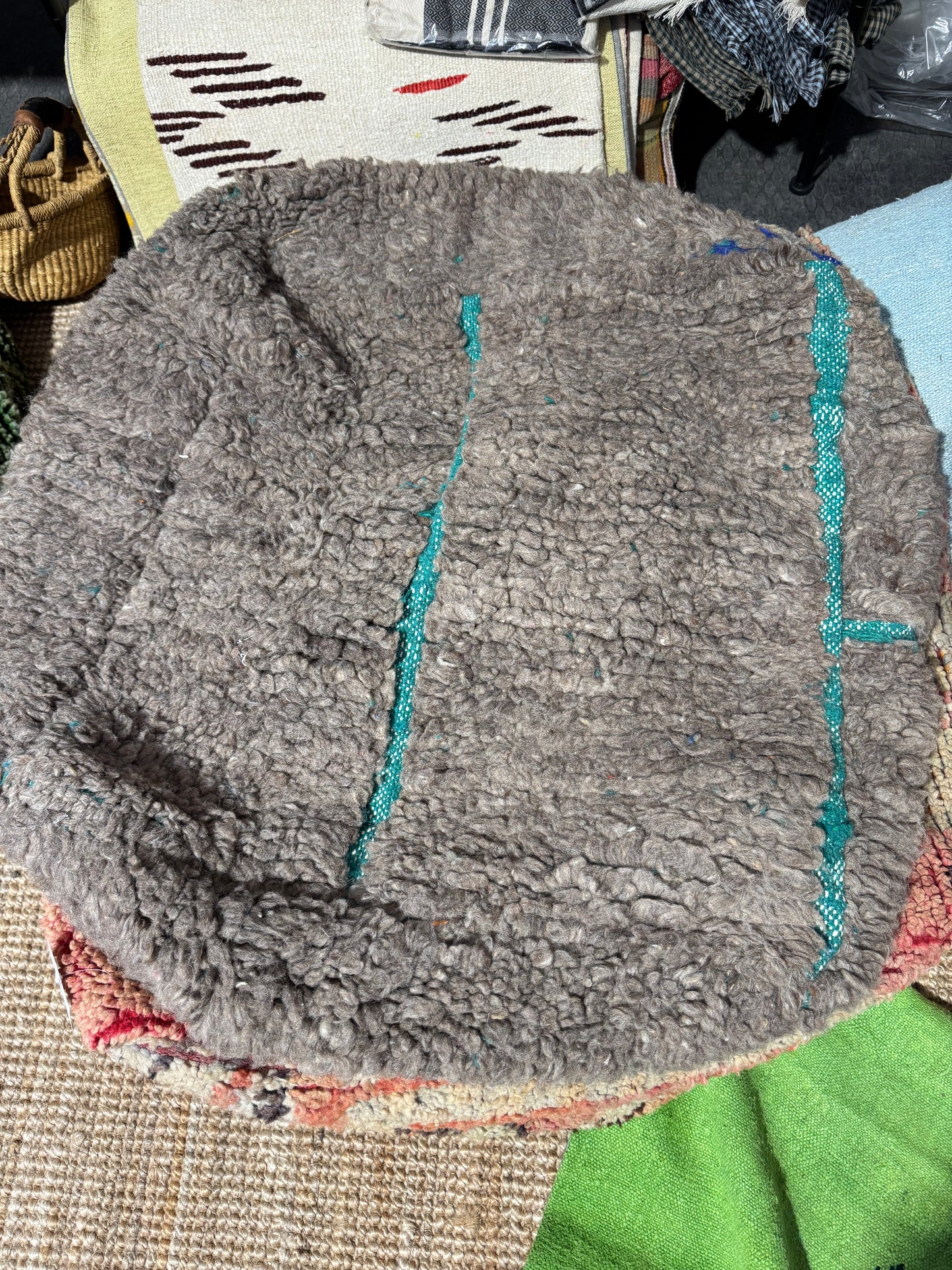Round gray rug with blue accents on a colorful rug