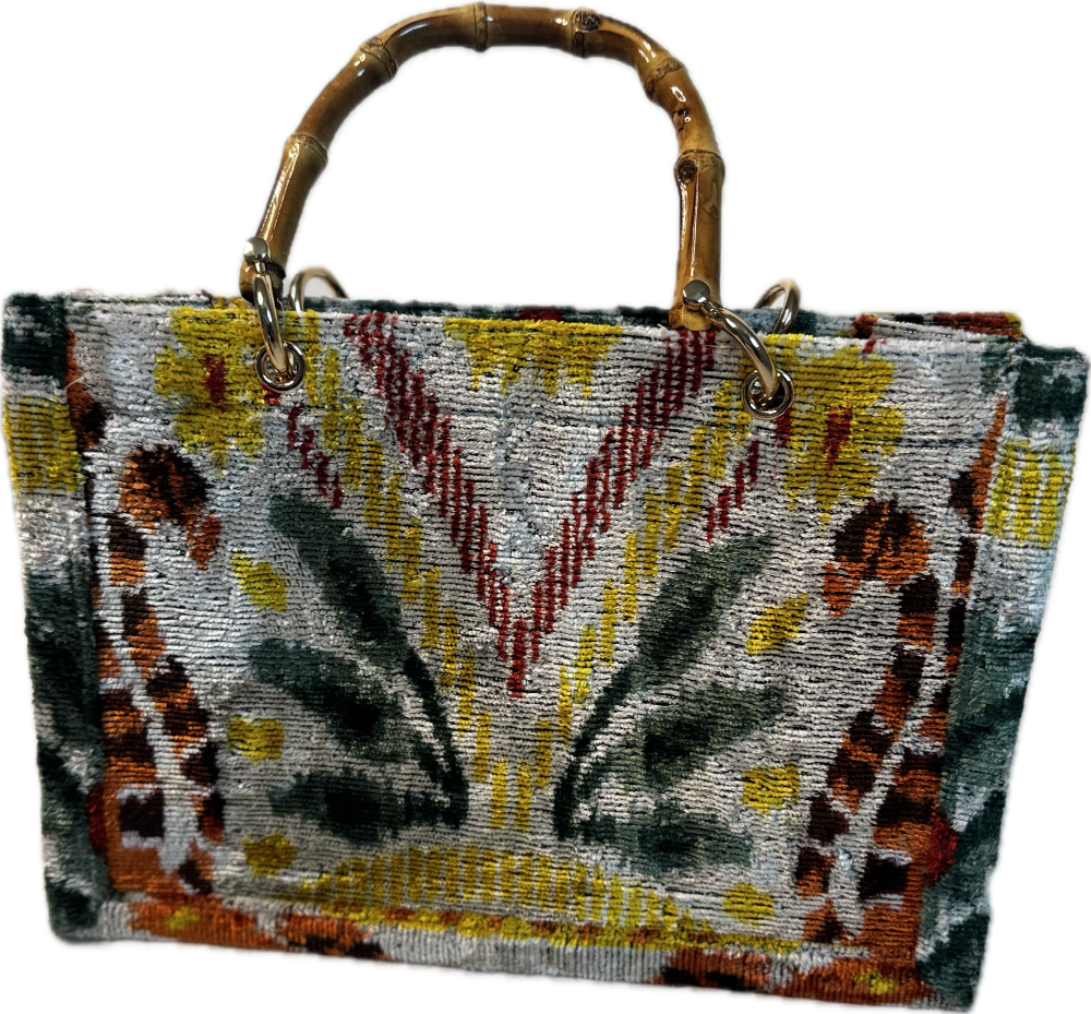 Handbag with a patterned design and bamboo handle on a white background