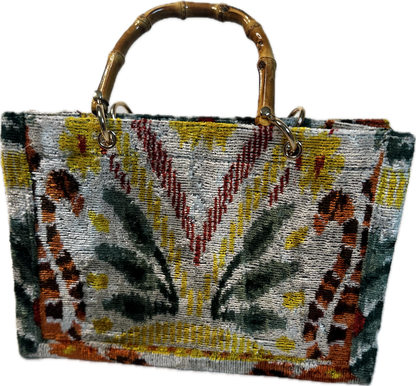 Handbag with a patterned design and bamboo handle on a white background