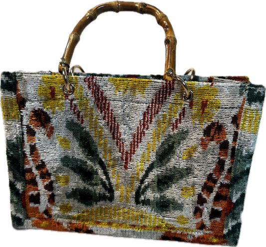 Handbag with a patterned design and bamboo handle on a white background