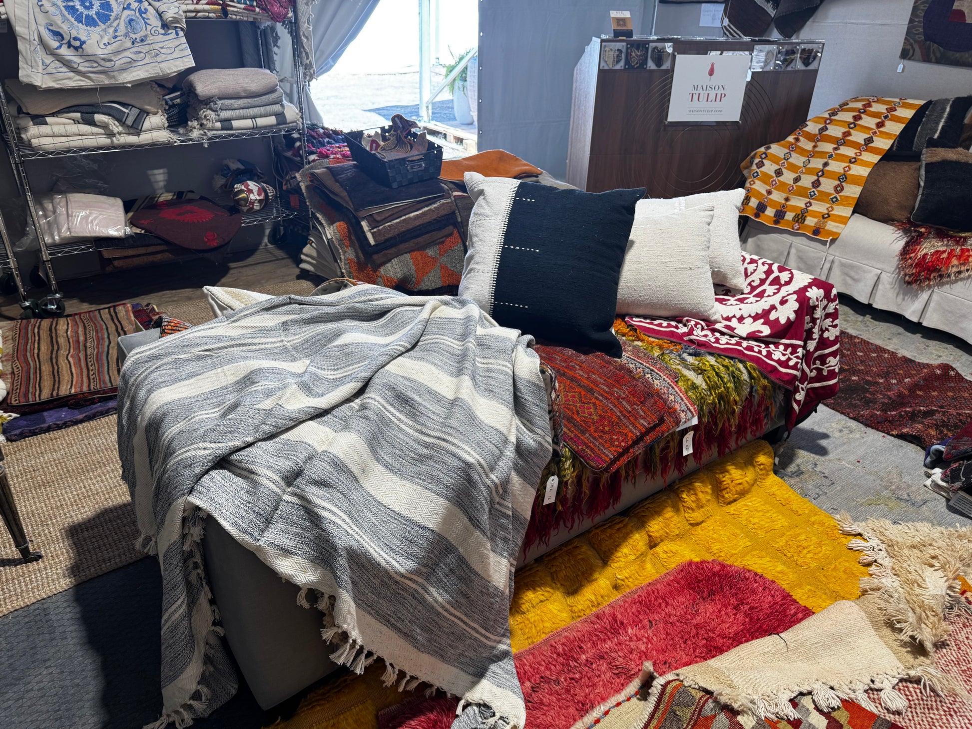 Living room with various rugs and furniture in a store setting