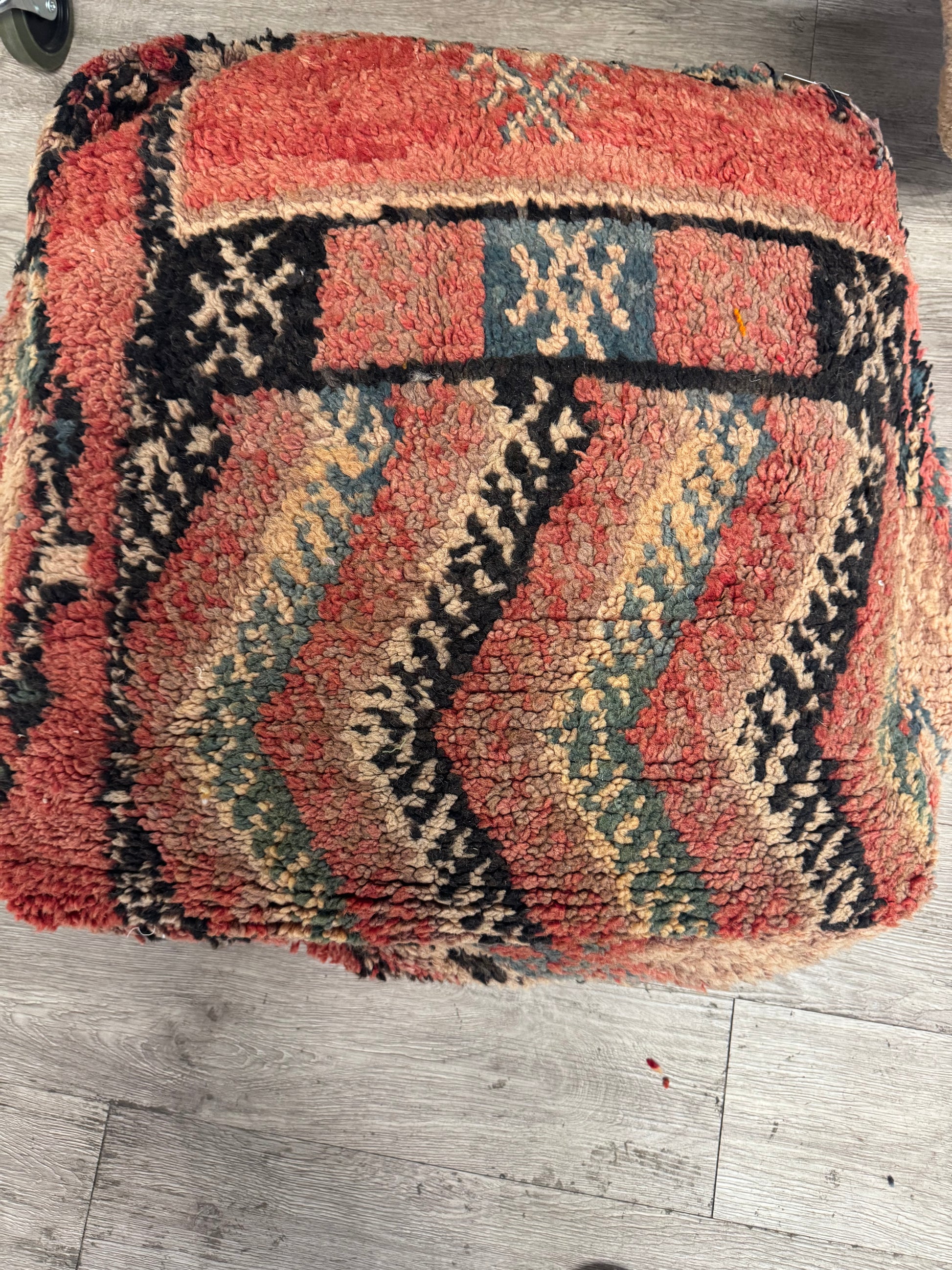 Textured rug with geometric pattern on a wooden floor