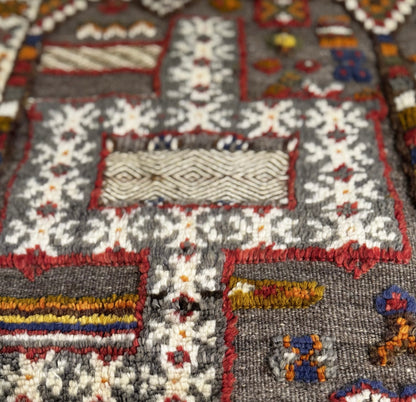 Moroccan Taznakht Kilim close -up of a textured fabric with colorful patterns and designs.