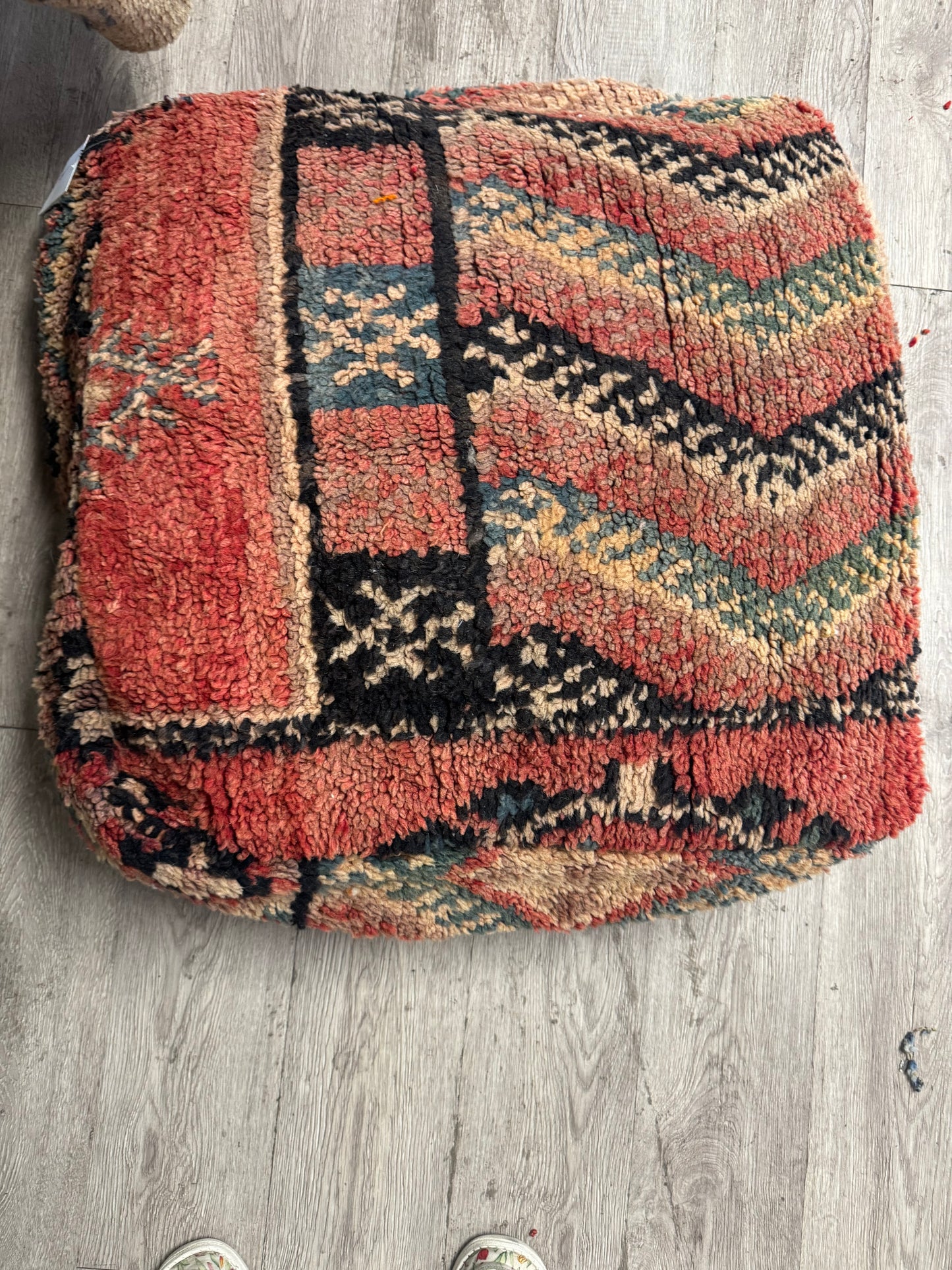 Textured rug with geometric pattern on a wooden floor